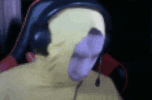 a blurry picture of a man wearing headphones and a yellow jacket