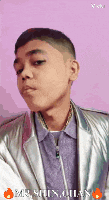a young man is wearing a silver jacket and a purple shirt with the name mr. shin chan on the bottom