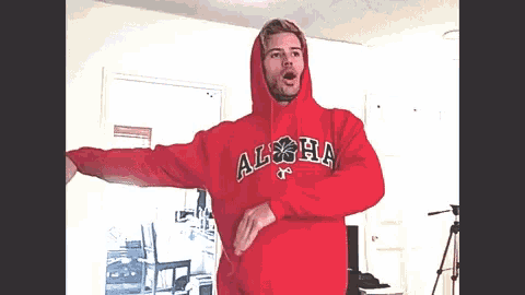 a man is wearing a red hoodie that says alpha on it