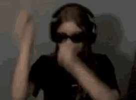 a girl wearing headphones and sunglasses is sitting with her arms crossed