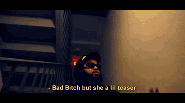 a man wearing sunglasses and a hat says bad bitch but she a lil teaser in a video