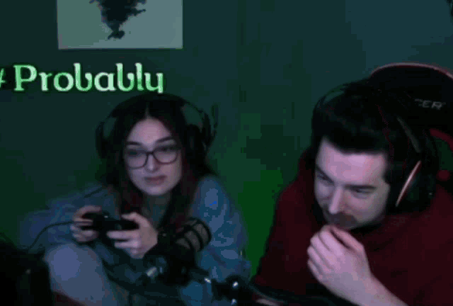 a man and a woman are playing a video game together while wearing headphones and smiling .