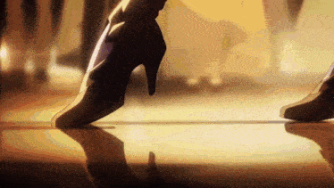 a close up of a person 's feet in high heels walking on a floor .