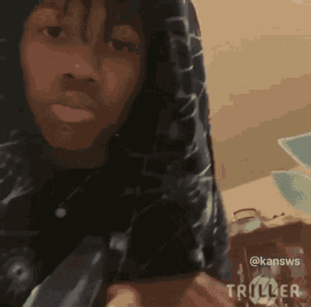 a man wearing a hoodie is making a funny face .