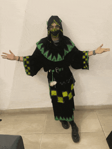a person wearing a black and green costume with a hood