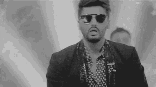 a black and white photo of a man wearing sunglasses .