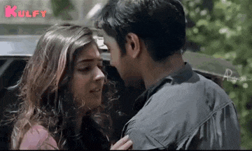 a man and a woman are kissing in a car .