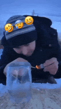 a man in a black hat is lighting a cigarette in a glass .