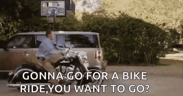 a man is riding a motorcycle next to a van with the words `` gonna go for a bike ride you want to go '' .