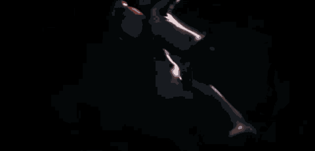 a silhouette of a woman in a hat is standing in front of a light .