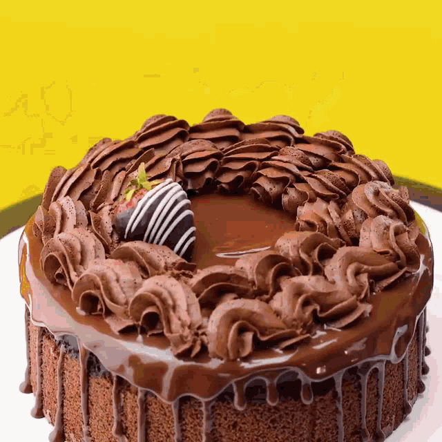 a chocolate cake with frosting and a strawberry on top