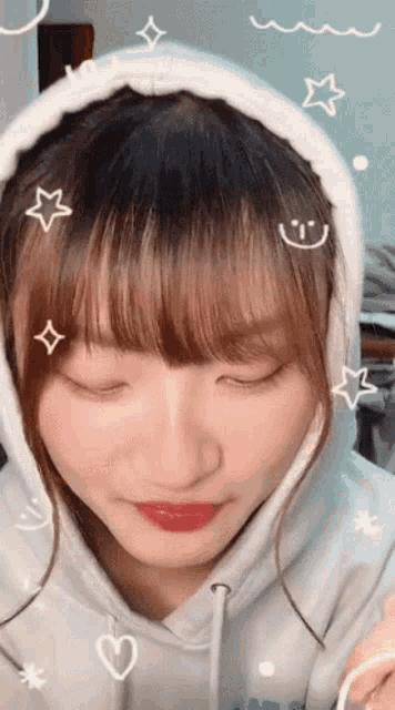 a girl wearing a white hoodie with a smiley face on her head