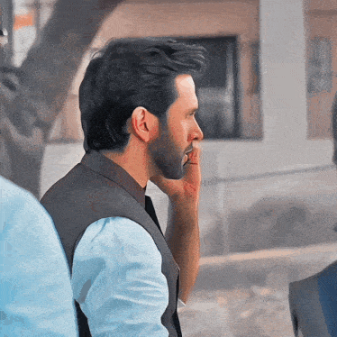 a man with a beard is talking on a cellphone