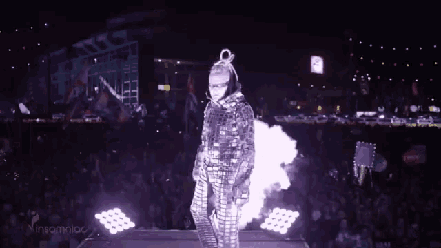 a person in a mirrored outfit is walking on a stage with the words insaniag visible in the corner
