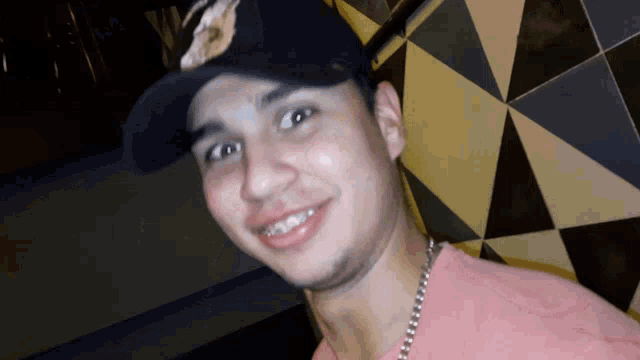 a man with braces on his teeth wears a hat
