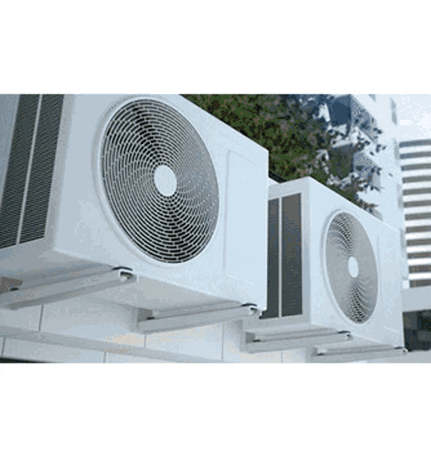 two air conditioners are mounted to the side of a building .