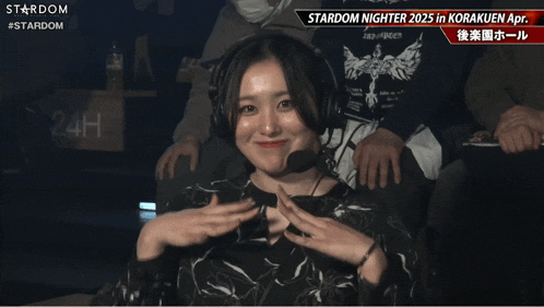 a woman wearing headphones and a microphone is sitting in front of a sign that says stardom