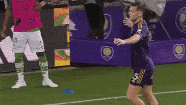 a soccer player in a purple jersey with the number 23 on it