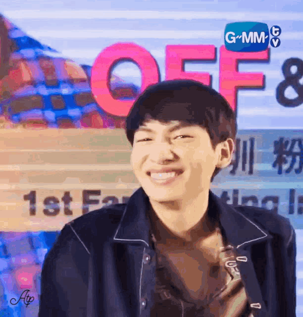 a young man is smiling in front of a sign that says " off "