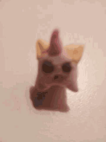 a close up of a stuffed animal with a unicorn horn on a white background .