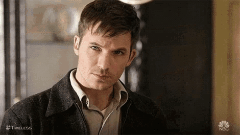 a man wearing a jacket and a shirt is looking at the camera .