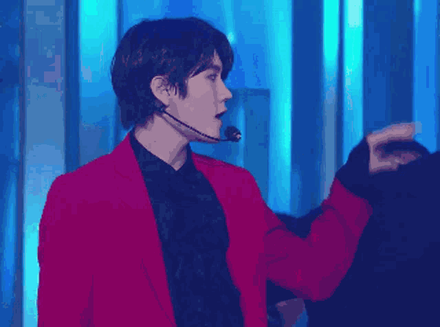 a man wearing a pink jacket and a black shirt is dancing