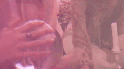 a woman is holding a glass ball with a purple light inside of it .