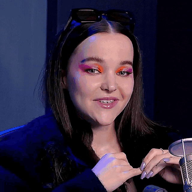 a woman wearing sunglasses has a pink eyeshadow on her eyebrows