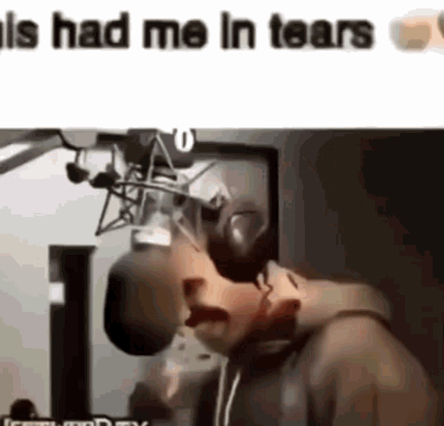 a man is crying in front of a microphone .
