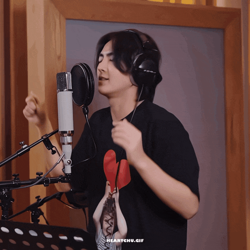 a man wearing headphones singing into a microphone with the words heartchu.gif above him