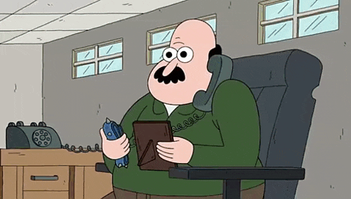 a bald man with a mustache is sitting in a chair talking on a telephone while holding a picture frame .