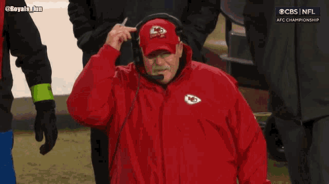a man wearing a chiefs hat and a red jacket
