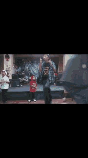 a man in a plaid shirt is dancing on a stage with another man in a green shirt