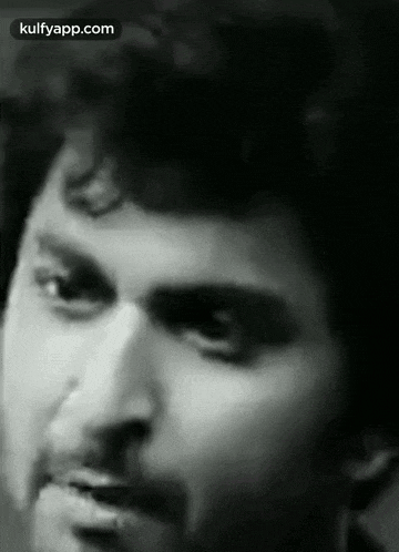 a black and white photo of a man 's face with his mouth open .