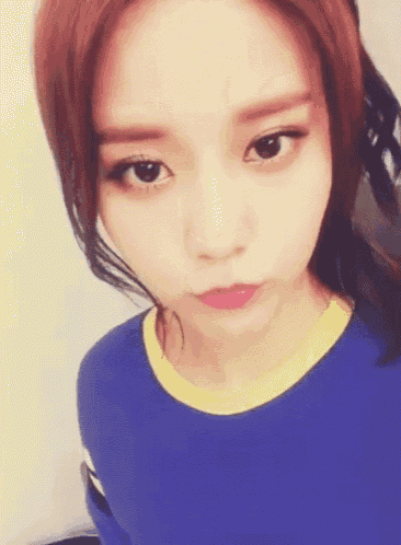 a girl with red hair is wearing a blue shirt and a yellow collar