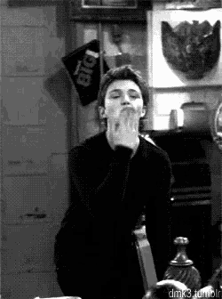 a black and white photo of a man blowing a kiss with a sign in the background that says pub