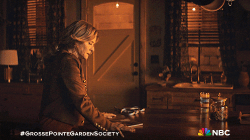 an advertisement for grosse pointe garden society shows a woman sitting at a table in a kitchen