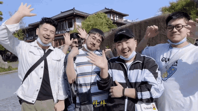 a group of young men are posing for a picture with one wearing a white shirt that says gln