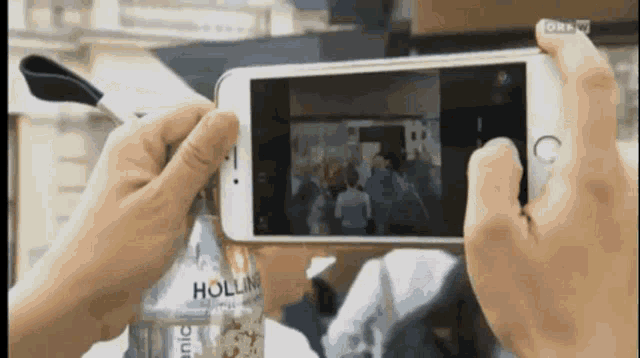 a person is taking a picture with a cell phone that says hollin
