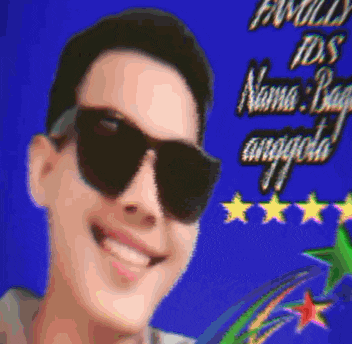 a man wearing sunglasses smiles in front of a blue background