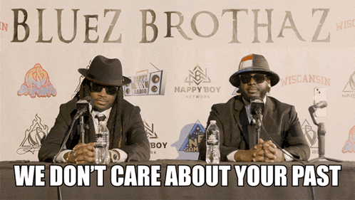 two men sitting at a table in front of a banner that says bluez brothaz