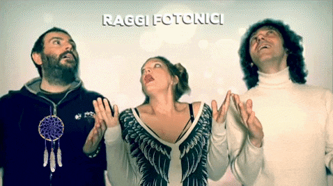 a man and two women are standing in front of a sign that says ' raggi fotonici '