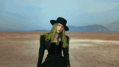 a woman with green hair wearing a black hat and a black dress