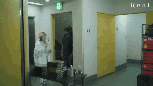 a person standing in a hallway with a sign that says real