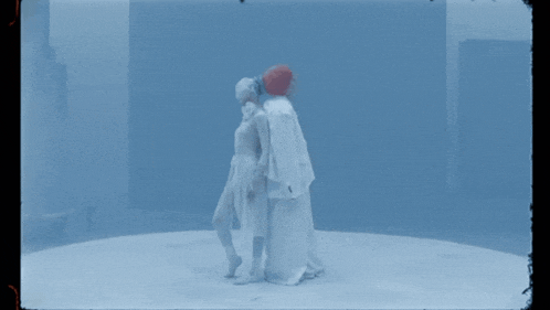 a couple of people in white standing in a circle
