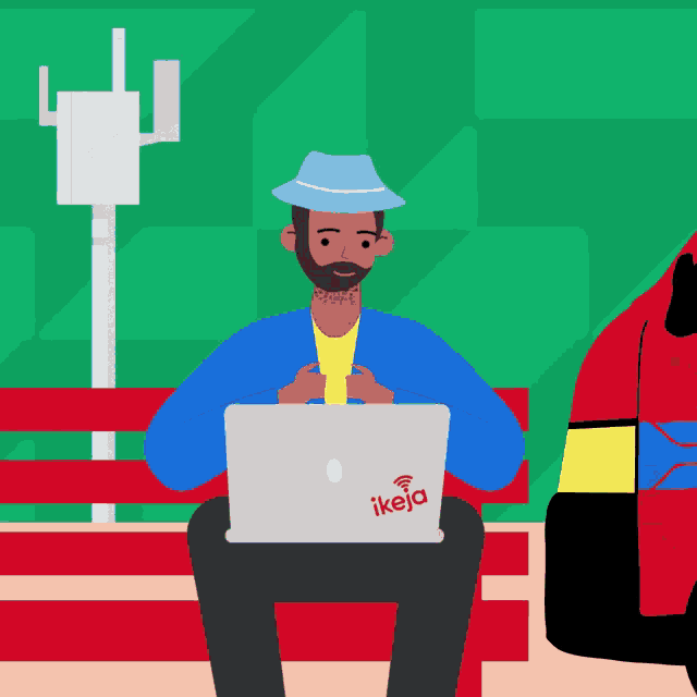 a man sits on a bench using a laptop with a sticker that says ikeja