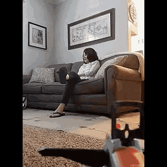 a woman is sitting on a couch reading a book .