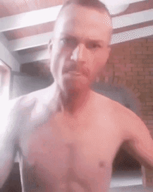 a man without a shirt is taking a selfie