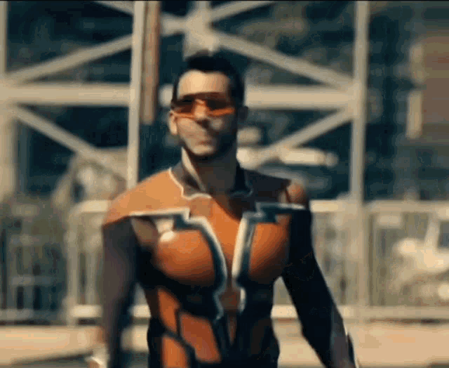 a man in a superhero costume and sunglasses is walking down the street .