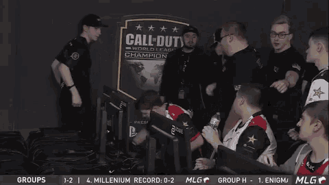 a group of men sitting in front of a sign that says call of duty
